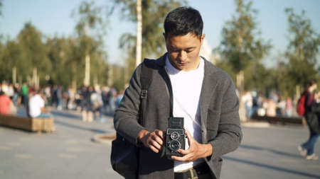Front portrait shot of a young Asian man taking a picture of Red Square in Moscow. Tourist Travel concept.の写真素材