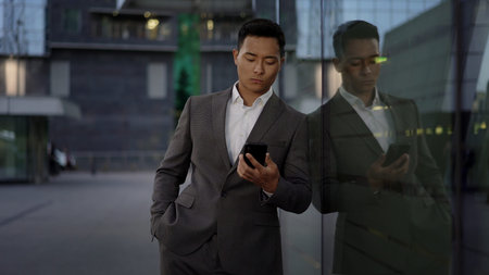 Front view of a young asian businessman, leading correspondence on the phone. Financial business area.の写真素材