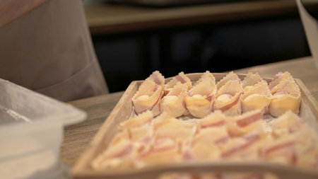 Tortellini in rows on a wooden tray close up, on wooden kitchen table at the restaurant kitchen....