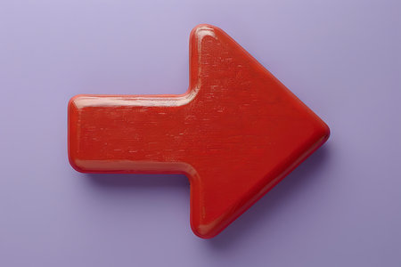 A glossy red arrow shape is prominently displayed, pointing right on a smooth light purple surface, highlighting a vibrant contrast and simple design..の素材