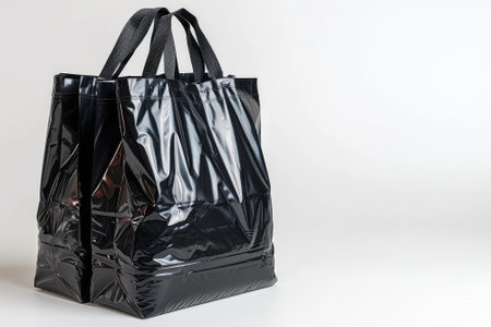 The black reusable bag, made of durable material, is positioned upright, showing its spacious design. Ideal for carrying groceries or personal items, it emphasizes sustainability and convenience..の素材