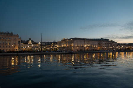 Strolling along the banks of Trieste between reflections of the sea and ancient buildingsの写真素材