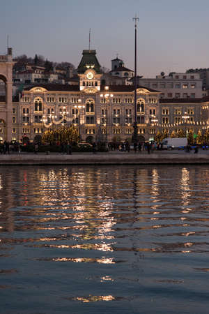Reflections on the sea of ??Trieste at dusk - Historical buildings and lightsの写真素材