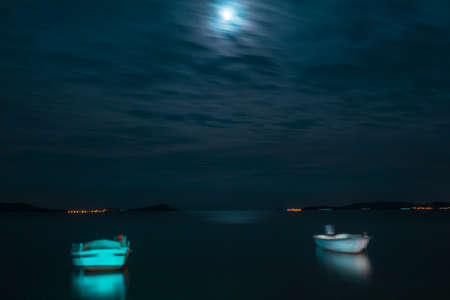 Moonlight, sea and boatsの写真素材