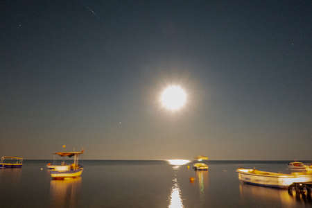 Seascape and boats in moonlightの写真素材