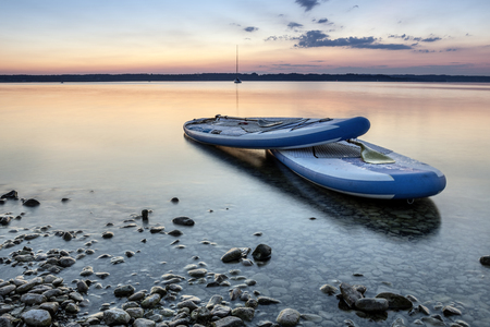 Sunset atmosphere with a view of 2 stand up paddling boards on the shores of Lake Starnbergの写真素材