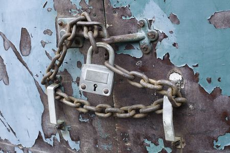 lock and chain on an old weathered blue doorの写真素材