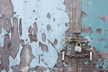 lock and chain on an old weathered blue door