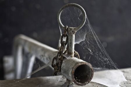 rusty chain on iron bar covered with spinragの写真素材