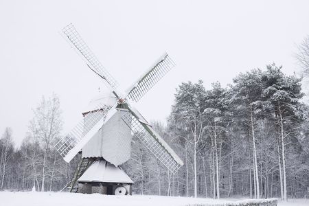 old wooden windmill covered in snowの写真素材