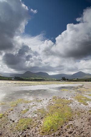 White clouds in blue sky over Irish hills and estuary at Dingle peninsula Kerry district Irelandの写真素材