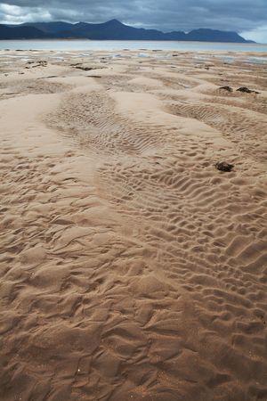 sandy beach with nice pattern in sand and water clouds and hills in background with copy space Dingle peninsula Irelandの写真素材