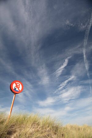 no bathing or swimming  sign in the dunes long grass blue sky white clouds background with copy spaceの写真素材