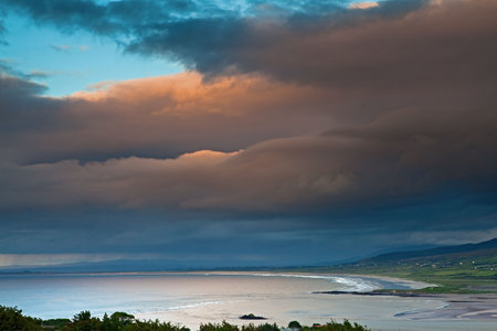 dark clouds during sunset over Irish coast Dingle peninsula Kerry district hills and beach long exposure image give a dramatic lookの写真素材