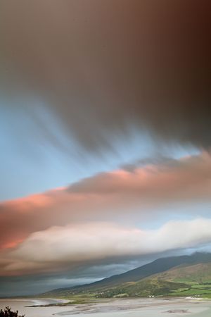 dark clouds during sunset over Irish coast Dingle peninsula Kerry district hills and beach long exposure image give a dramatic lookの写真素材