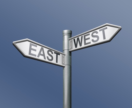 east west road sign on blue backgroundの写真素材