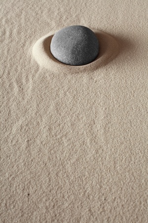 zen meditation stone relaxation or concentration point to focus and to meditate round grey rock in dry sand simplicity and purity spa background abstract conceptの写真素材