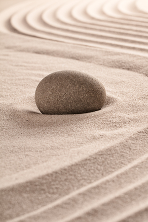 Purity concept by round stone on raked sand in zen meditation garden.の写真素材