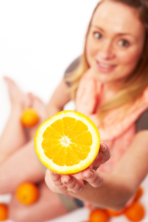 Young pretty woman with orangeの写真素材