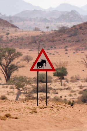 A road-sign at a Namibian gravel road cautioning against elephantsの写真素材