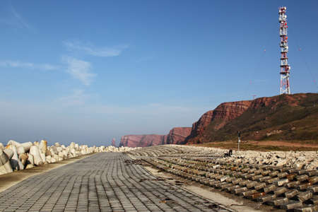 Cliff coast of Helgoland with the radio tower and the famous Tall Anna rock in the background.の写真素材