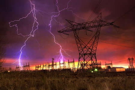 Dramatic Image of Power Distribution Station with Lightning Striking Electricity Towers.の写真素材