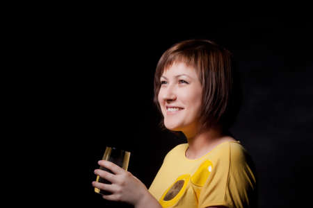 young woman with glass water, black backgroundの写真素材