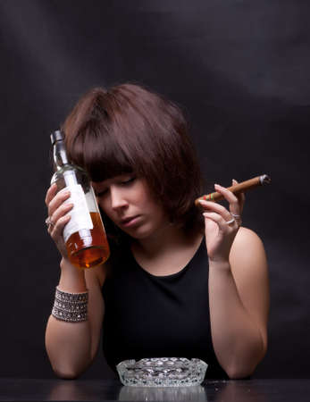 photo of woman drinks alcohol and smokes a cigarの写真素材
