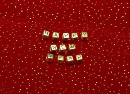 photo of phrase "happy new year" of beads on a red velvet with sequinsの写真素材