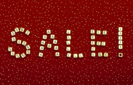 photo of word "SALE" of beads on a red velvet with sequinsの写真素材