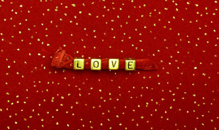 photo of word of love beads on red velvet with sequins