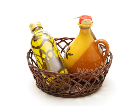 Bottle and jar of virgin olive oil in basket on whiteの写真素材