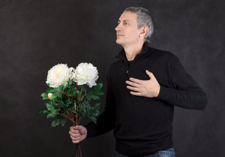 Man holding a bouquet of flowers on gray background