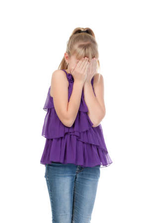 Young girl shyly covered her face with her hands, isolated on white backgroundの写真素材