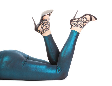 Cropped view of a woman lying on the floor kicking her sexy shapely legs in shimmering tights and...
