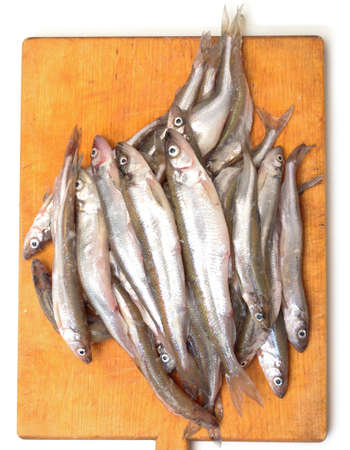 Fresh smelts fish on wooden cutting boardの写真素材