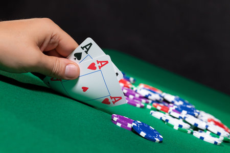 Colorful poker chips and two Ace closeup on green cloth