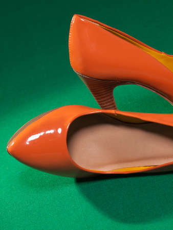 Female orange shoes on green cloth backgroundの写真素材