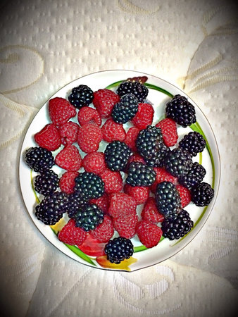 Raspberries and blackberries on the plate 