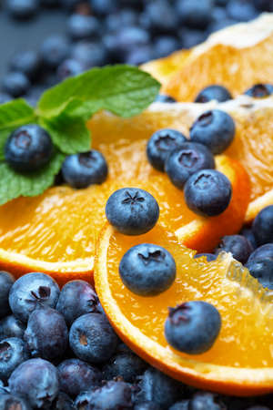 Freshly picked blueberries with orange, closeupの写真素材