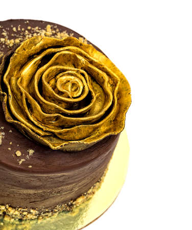 Chocolate Cake Sprinkled with Crumbs and Golden Rose, on white backgroundの写真素材