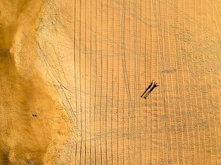 Long Shadows of the Late Afternoon Sun Two People on a Sandy Beach, aerial shotの写真素材
