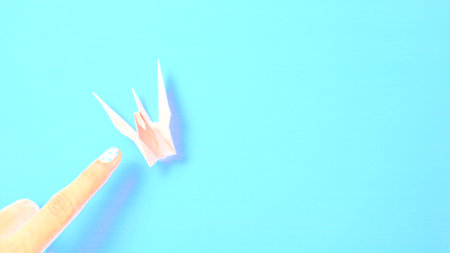 Pink paper bird in blue background.の写真素材