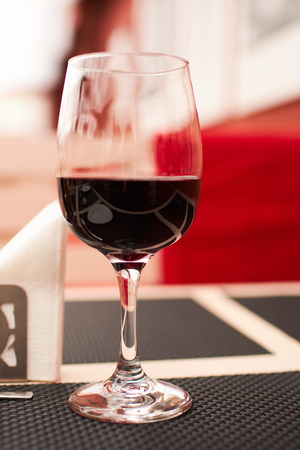 glass of red wine in cafeの写真素材