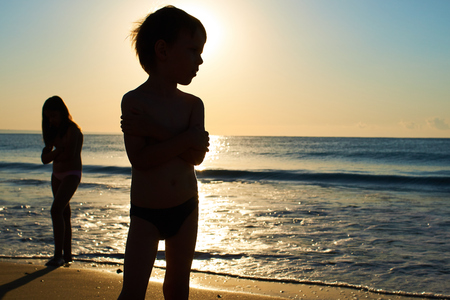 sister and brother dawn sunset at the seaの写真素材
