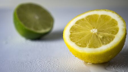 sliced lime and lemon on a white backgroundの写真素材