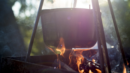 cauldron on fire. cooking soup close up to fireの写真素材