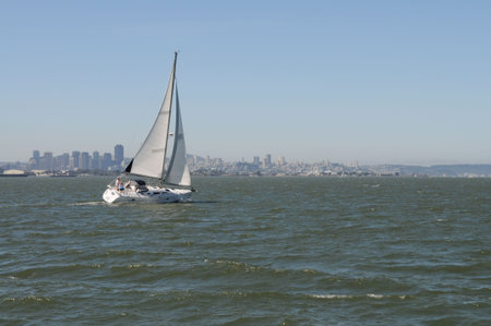 A sailboat on San Francisco Bay, with the city in the backgroundの写真素材