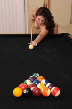 Adorable young brunette at the pool table