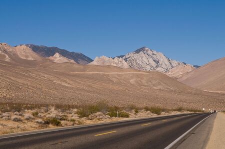 Highway through brown hills near Inyokern, Californiaの写真素材